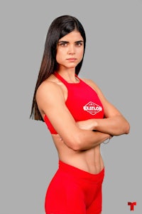 a woman in a red bodysuit with her arms crossed