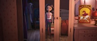 a girl is standing in a room with a pink door