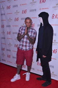 two men standing next to each other on a red carpet