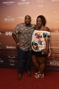 a man and woman posing on a red carpet