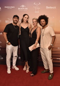 a group of people posing for a photo on a red carpet