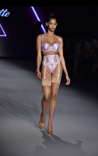 a model in lingerie walking down the runway