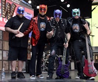 a group of men with masks and guitars