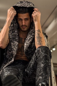 a man sitting on a chair with tattoos