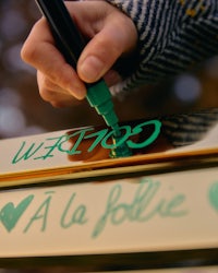 a person writing a message on a piece of wood