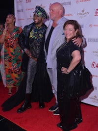 three people posing for a photo on the red carpet