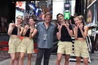 a group of girls posing for a photo in times square