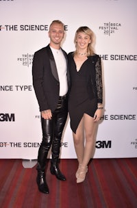 a man and woman posing on a red carpet