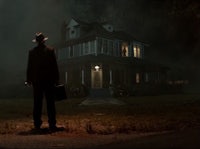 a man standing in front of a house at night