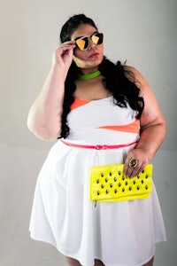 a woman in a white dress with a yellow clutch