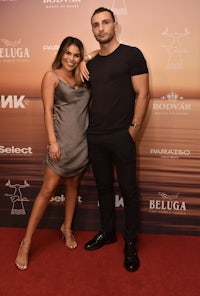 a man and woman posing on a red carpet