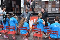 a group of people in blue shirts sitting in chairs