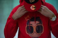 a man wearing a red hoodie and sunglasses