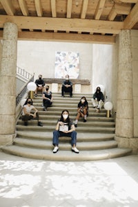 a group of people sitting on steps in front of a building