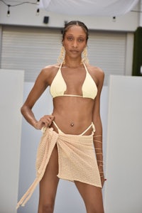 a woman in a yellow bikini posing on a runway