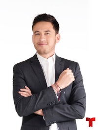 a man in a suit posing with his arms crossed