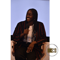 a woman sitting in a chair holding a microphone