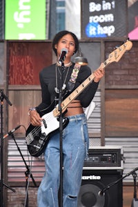 a woman playing a bass guitar on stage