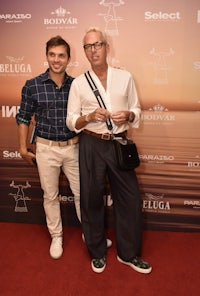 two men standing on a red carpet at an event