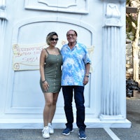 a man and woman standing in front of a white building