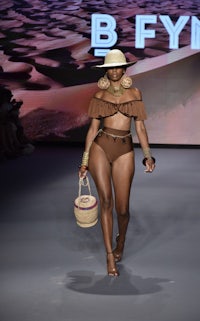 a woman in a bikini walks the runway at b fynn fashion week