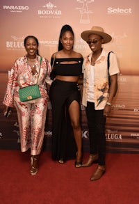 three people posing for a photo on the red carpet