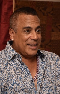 a man in a blue and white shirt is sitting down