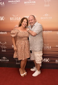 a man and woman posing for a photo on a red carpet