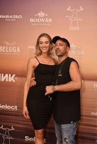 a man and woman posing for a photo on the beach