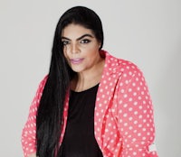 a woman in a pink polka dot jacket posing for a photo