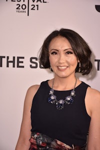 a woman in a black dress standing on a red carpet