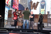 a group of people standing on a stage in times square