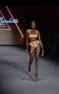 a woman in lingerie walking down the runway