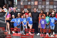 a group of young people posing for a photo in front of a stage