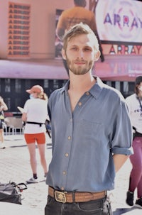 a man in a blue shirt standing in front of a building