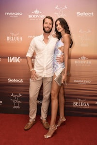 a man and woman posing on a red carpet