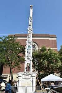 a white clock tower in front of a brick building