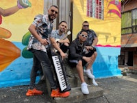 a group of men posing in front of a colorful building