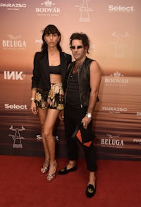 a man and woman posing on a red carpet