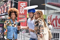 two people talking to a reporter on a street in times square