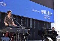 a man is playing a keyboard in front of a large screen