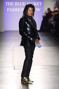 a man in a suit walking down the runway at the blue jacket fashion show