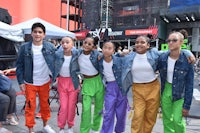 a group of young people posing for a photo in front of a building