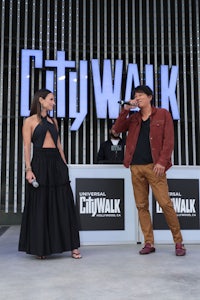 a man and woman standing in front of a citywalk sign