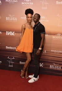 a man and woman posing on a red carpet