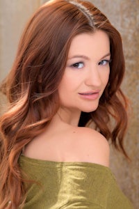 a woman with long red hair is posing for a picture