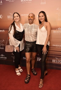 three women posing for a photo on a red carpet