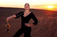 a woman holding a tassel in the desert