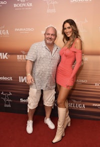 a man and woman posing on a red carpet