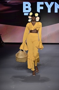 a woman in yellow on the runway